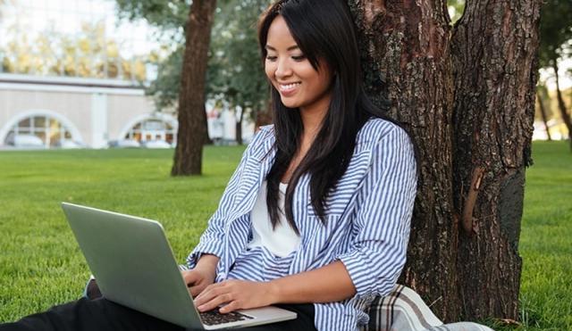 Woman outside looking at computer